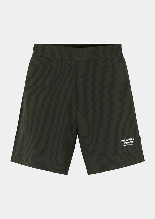 Front view of the Pas Normal Studios Men’s Balance Shorts  in the color dark olive green. Adjustable elastic waistband and tight fit with Pas Normal Studio font logo in white on lower left side. Not a tight fitting short.