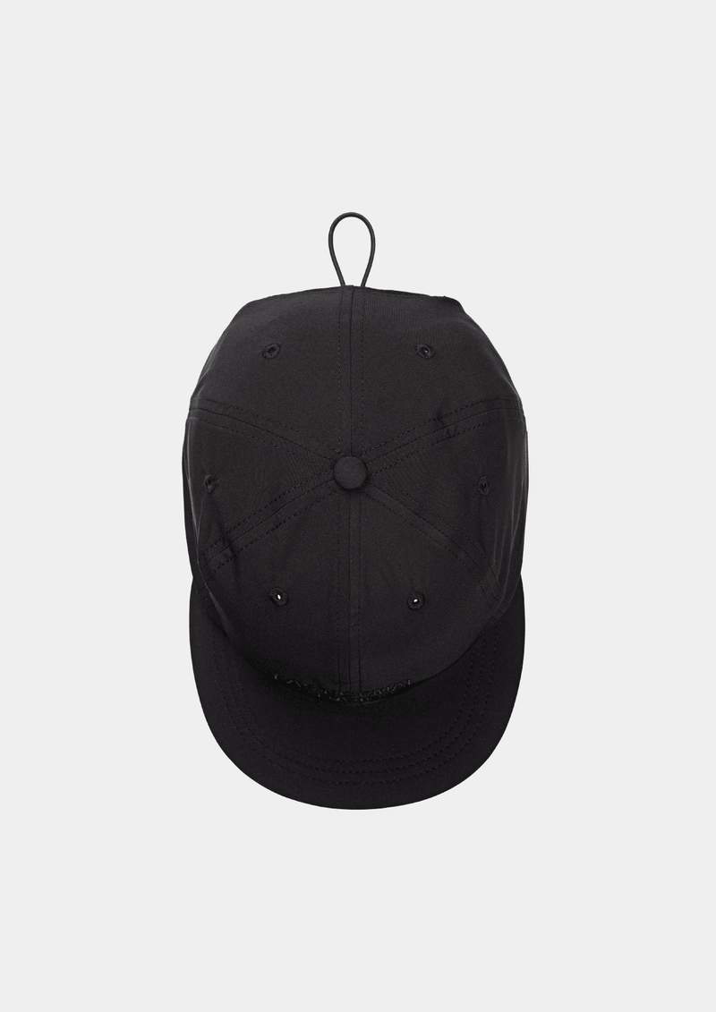 Top down view of the Pas Normal Studios Balance Cap in the color Black. Six panel construction and ultra light nylon fabric. Featuring a vented opening on the back and completed with a toggled drawstring, the cap is highly breathable and close-fitting, making it nearly undetectable during use.