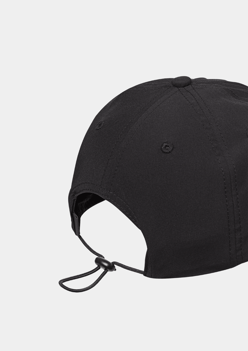 Back side view of the Pas Normal Studios Balance Cap in the color Black. Six panel construction and ultra light nylon fabric. Featuring a vented opening on the back and completed with a toggled drawstring, the cap is highly breathable and close-fitting, making it nearly undetectable during use.