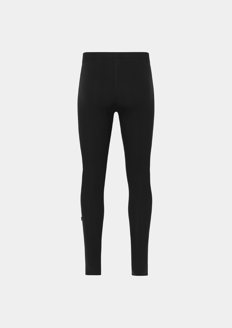 Back side view of the Pas Normal Studios Men’s Balance Long Tights in the color black. Perforated elastic waistband and tight fit. No logo markings on the back of the tights.