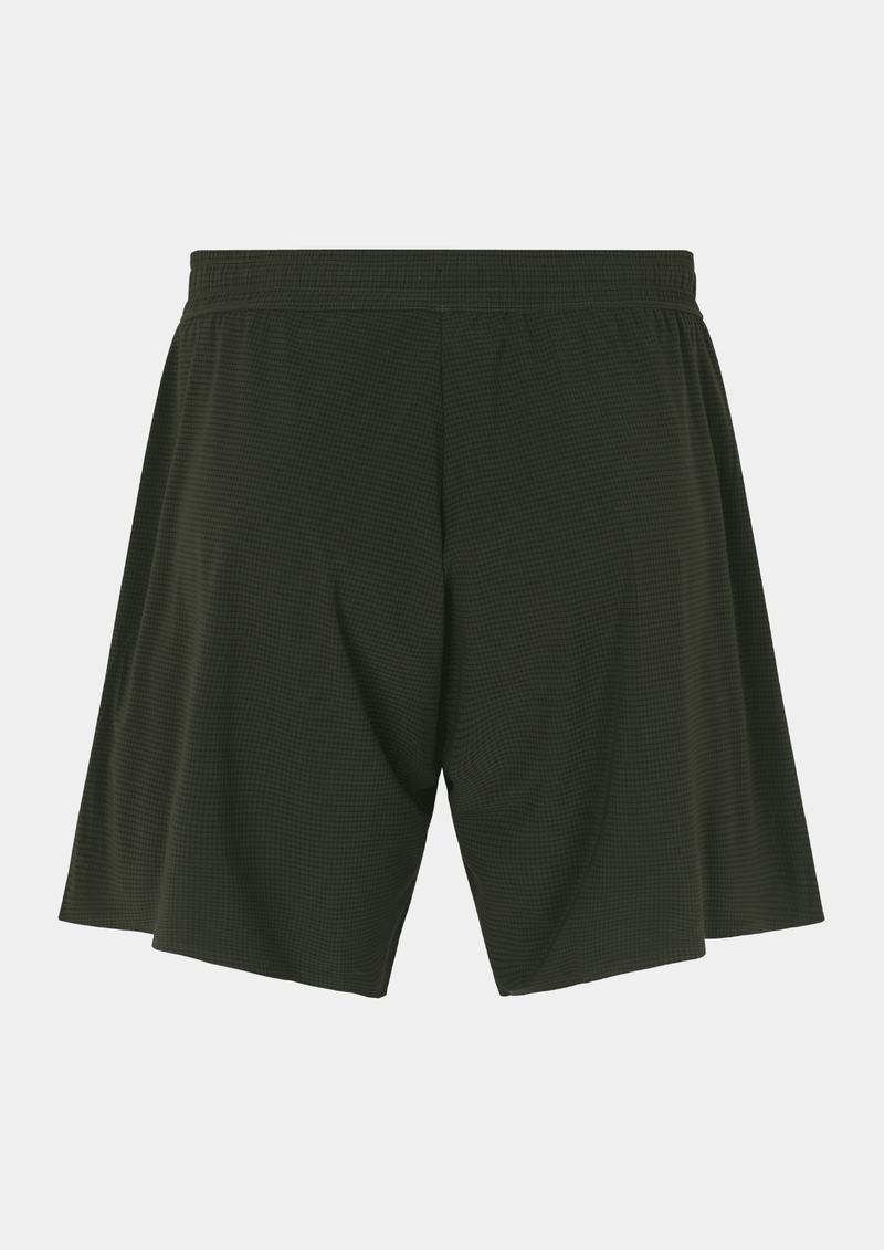 Back side view of the the Pas Normal Studios Men’s Balance Shorts in the color dark olive green. Adjustable elastic waistband and tight fit. No logo markings on the back of the shorts. Not a tight fitting short.