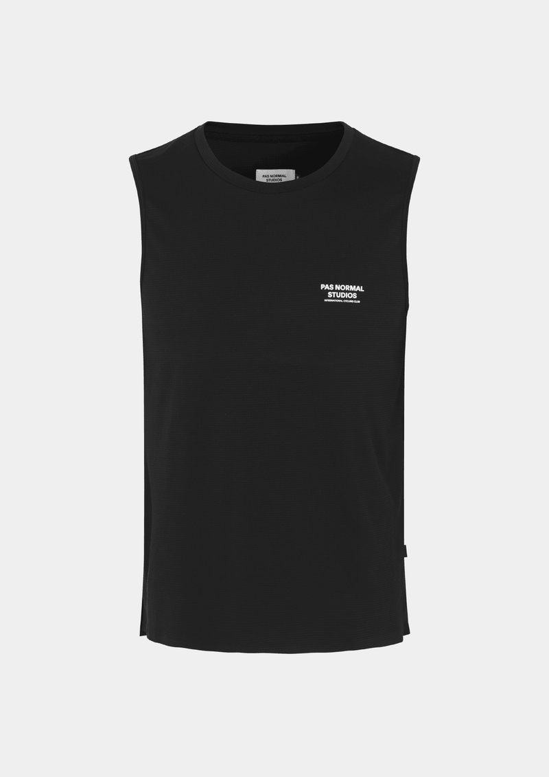 Front view of the Pas Normal Studios Men’s Balance Sleeveless Top in the color black. Knit construction and split hem vents. Pas Normal Studios text logo in white on front left breast of shirt. 