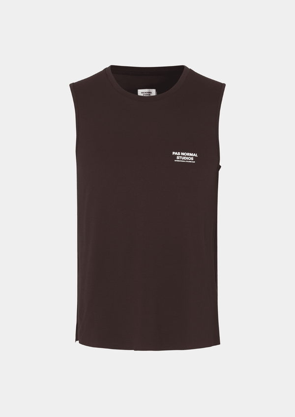 Front view of the Pas Normal Studios Men’s Balance Sleeveless Top in the color dark red. Knit construction and split hem vents. Pas Normal Studios text logo in white on front left breast of shirt. 