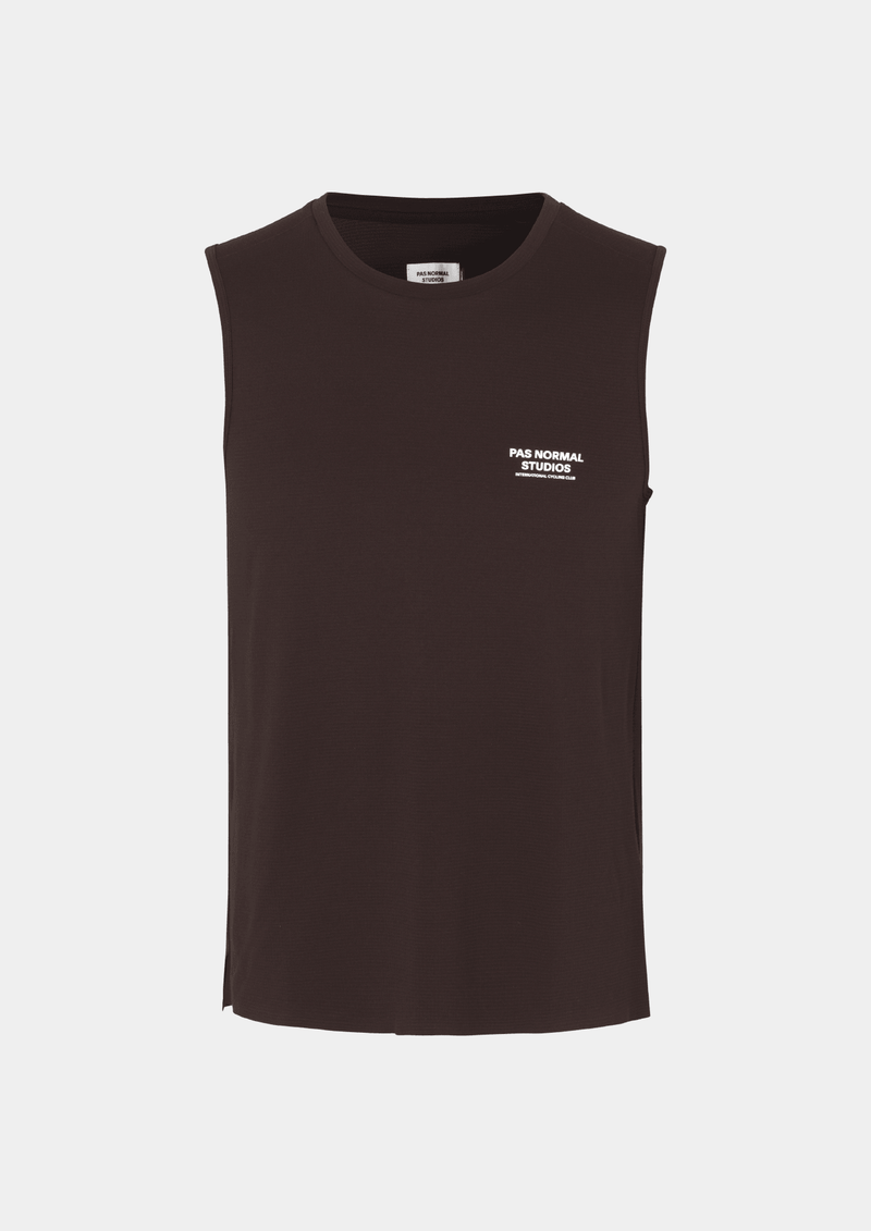 Front view of the Pas Normal Studios Men’s Balance Sleeveless Top in the color dark red. Knit construction and split hem vents. Pas Normal Studios text logo in white on front left breast of shirt. 