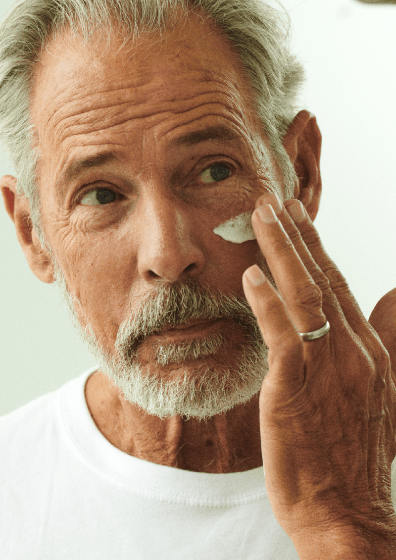 Photo of middle aged man applying the asystem daily defense moisturizer with SPF. 